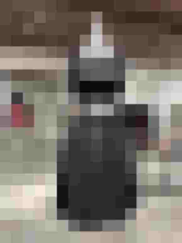 Schaufensterpuppe mit schwarzem Kleid und grauer Lodenschürze