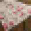Schürze mit pinken Blumenmustern auf hellem Hintergrund, perfekt für festliche Anlässe.