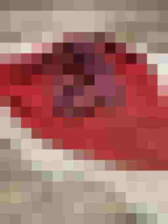dreieckstuch aus merinowolle in rot und flieder auf holzuntergrund